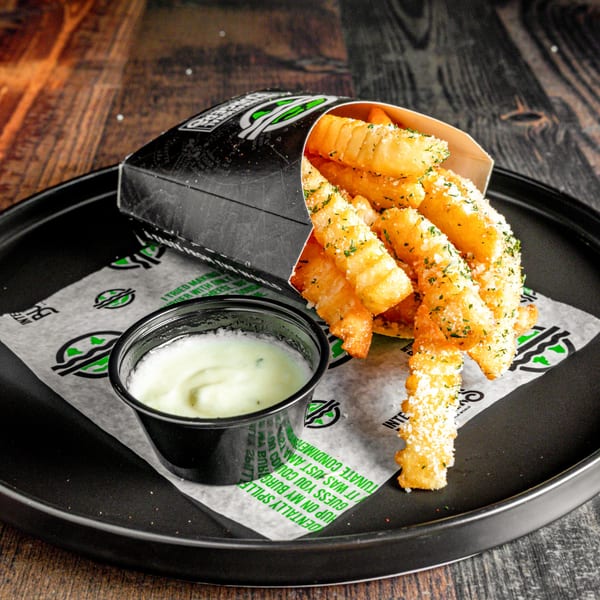 Crispy crinkle-cut fries with parmesan and parsley, served with a side of dipping sauce.