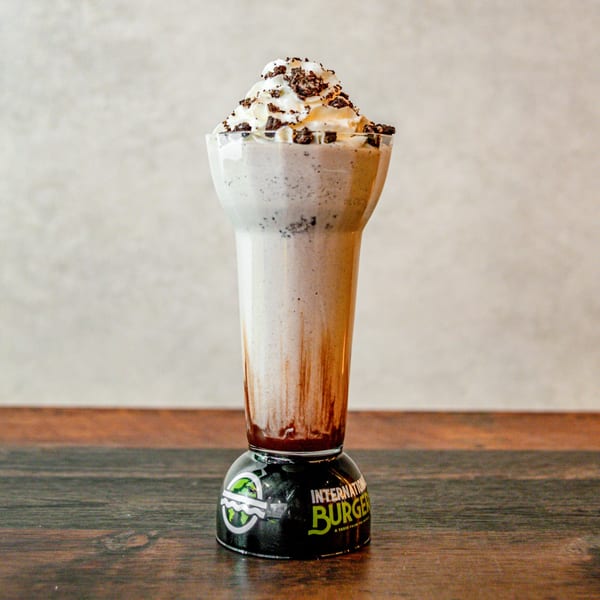 International Burgers' cookies and cream milkshake with whipped cream, chocolate drizzle, and cookie crumbles.